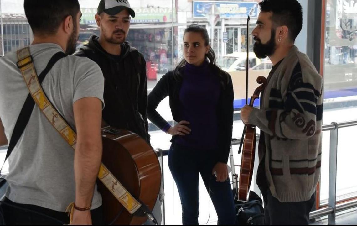 Mery Muñoz (centro) espera con otros músicos venezolanos para tocar en el sistema de transporte público a cambio de monedas, en Bogotá, Colombia.