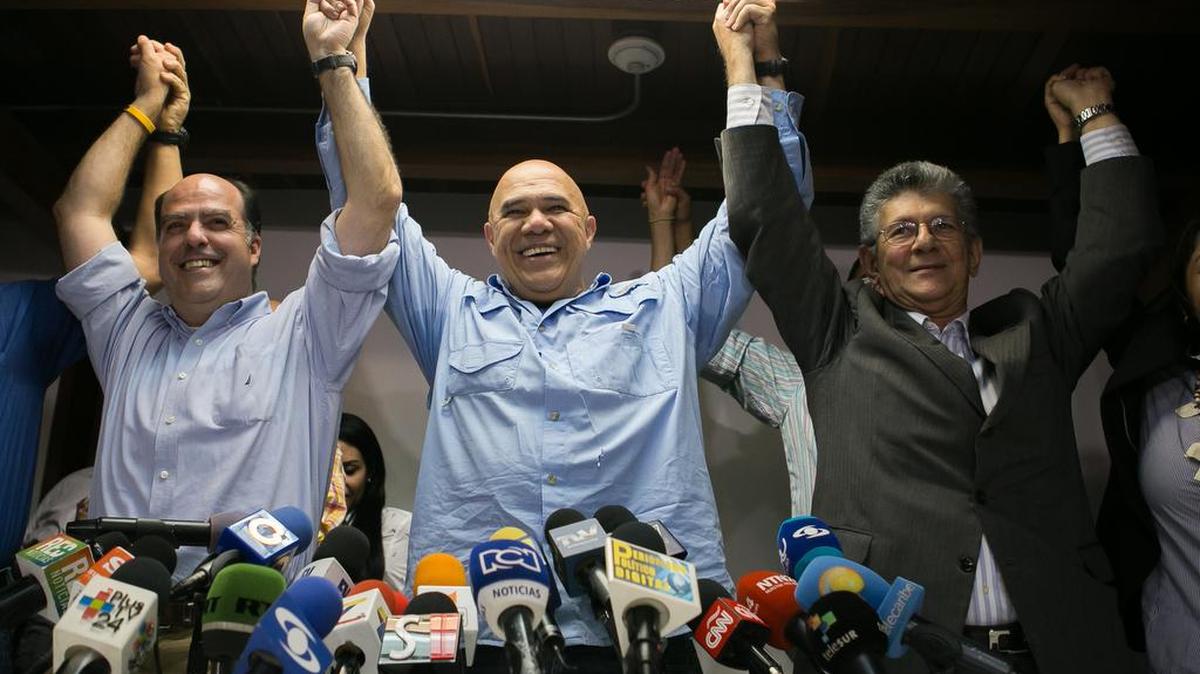 El secretario general de la alianza opositora venezolana Mesa de la Unidad Democrática (MUD), Jesús Torrealba (c), acompañado de los diputados Julio Borges (i) y Henry Ramos Allup (d), ofrece una rueda de de prensa el martes 29 de diciembre de 2015, en Caracas (Venezuela).