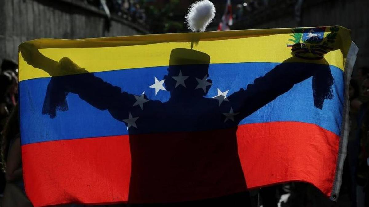 Un manifestante con la bandera venezolana rinde homenaje a los caídos en las protestas contra el gobierno de Maduro, en Caracas este lunes.