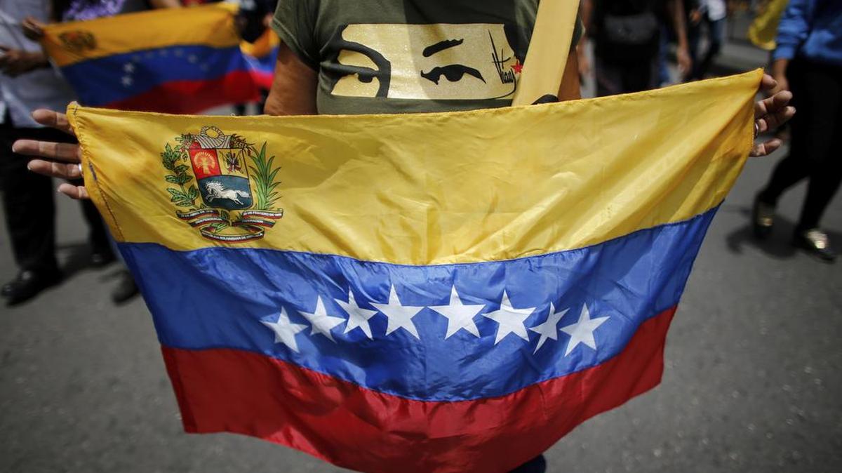 Un partidario del gobierno despliega la bandera nacional durante una marcha realizada el lunes en Caracas.