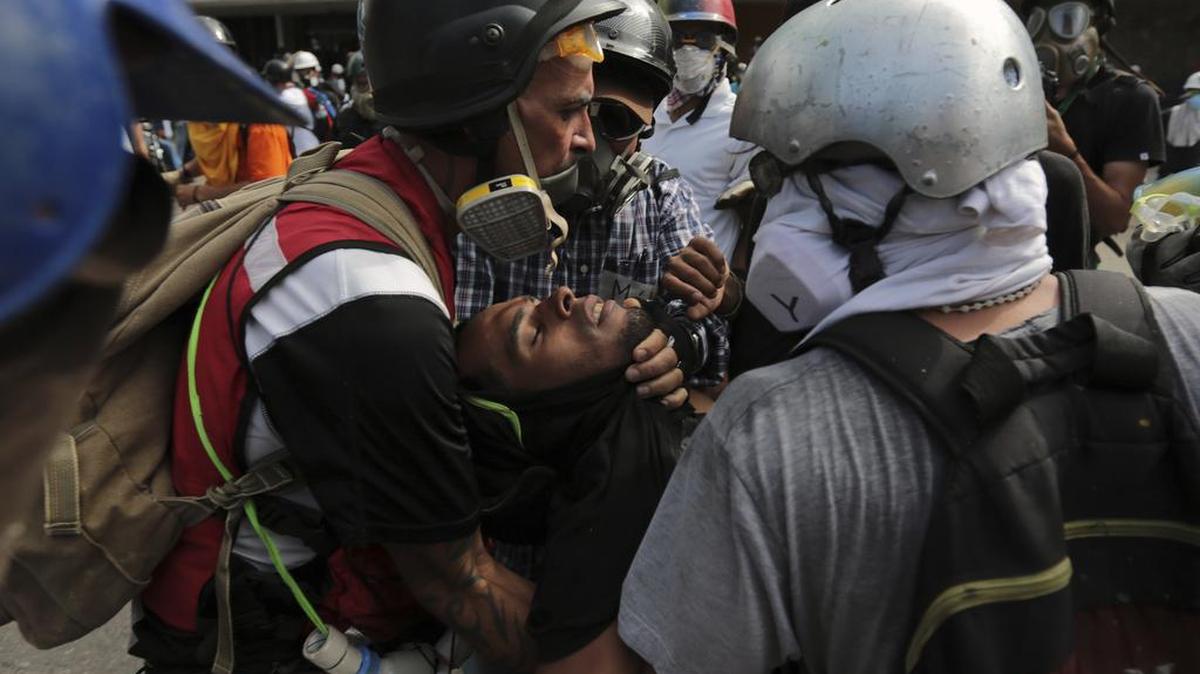 Un manifestante herido es transportado tras los enfrentamientos con la policía antidisturbios durante una marcha hacia la Defensoría del Pueblo en protesta contra el presidente Nicolás Maduro en Caracas, Venezuela, el lunes 29 de mayo de 2017.