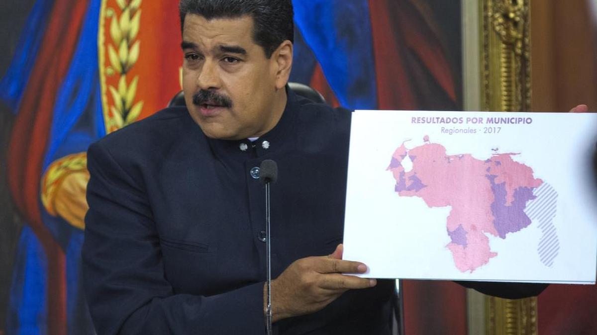 El presidente venezolano, Nicolás Maduro, sostiene un mapa con las regiones venezolanas destacadas en rojo donde los candidatos progubernamentales salieron victoriosos, durante una conferencia de prensa en el palacio presidencial de Miraflores, en Caracas, Venezuela, el martes 17 de octubre de 2017.