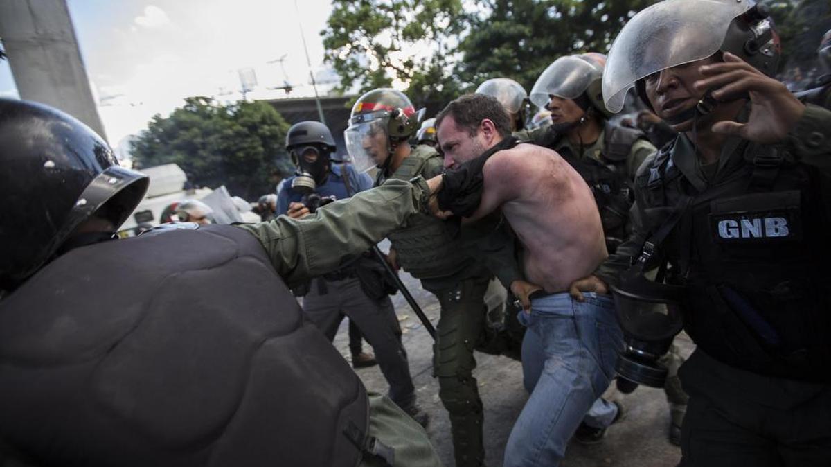 Miembros de la Guardia Nacional Bolivariana (GNB) detienen a un hombre durante una de las protestas en el marco de la huelga general convocada por la oposición el miércoles 26 de julio de 2017, en Caracas, Venezuela.