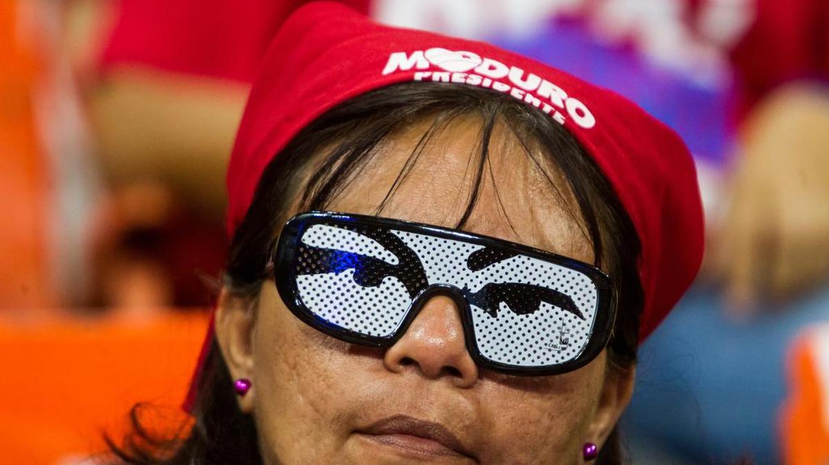 Una mujer porta unos lentes con una imagen de los ojos del fallecido presidente venezolano Hugo Chavez durante un evento de campaña electoral de la alianza chavista Gran Polo Patriótico (GPP), el lunes 30 de noviembre del 2015, en Caracas, Venezuela.