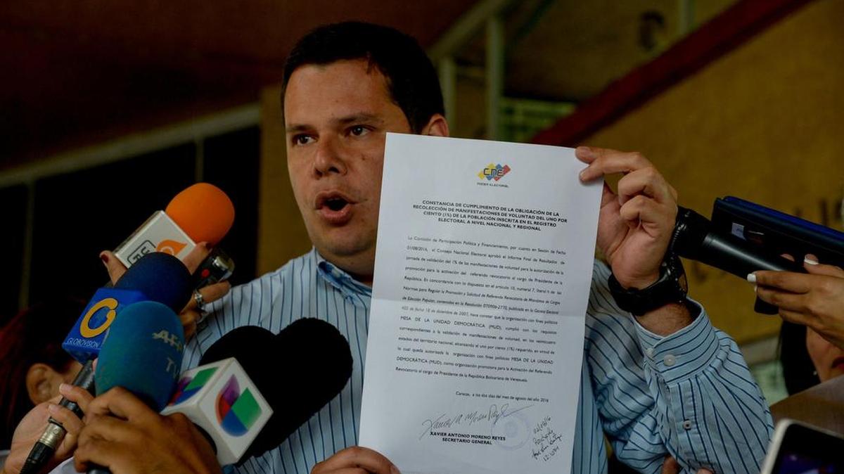 Diputado opositor Juan Carlos Caldera muestra el documento de certificación publicado por el Consejo Nacional Electoral de Venezuela (CNE), en la sede del CNE en Caracas, el 2 de agosto de 2016.