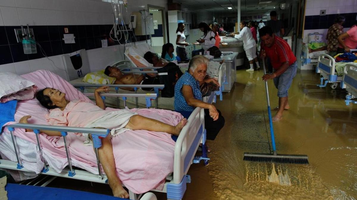 Un familiar de un paciente en Cumaná, Sucre, Venezuela, saca agua de una sala inundada por las lluvias. El hospital carece de abastecimiento en medicinas y de camas. La falta de higiene provoca que muchos pacientes mueran por bacterias en la sala de emergencias, en noviembre del 2016.