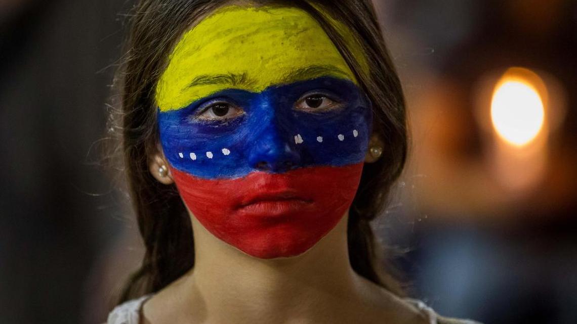 Una mujer con el rostro pintado con los colores de la bandera venezolana participa en una vigilia el sábado 29 de abril de 2017, en Caracas (Venezuela).