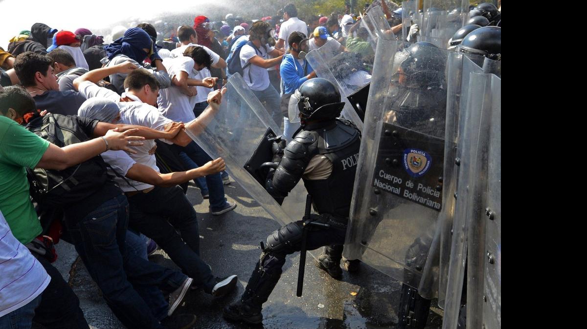 
Estudiantes venezolanos chocan con agentes policiales durante una manifestación antigubernamental en Caracas, en el 2014. 
