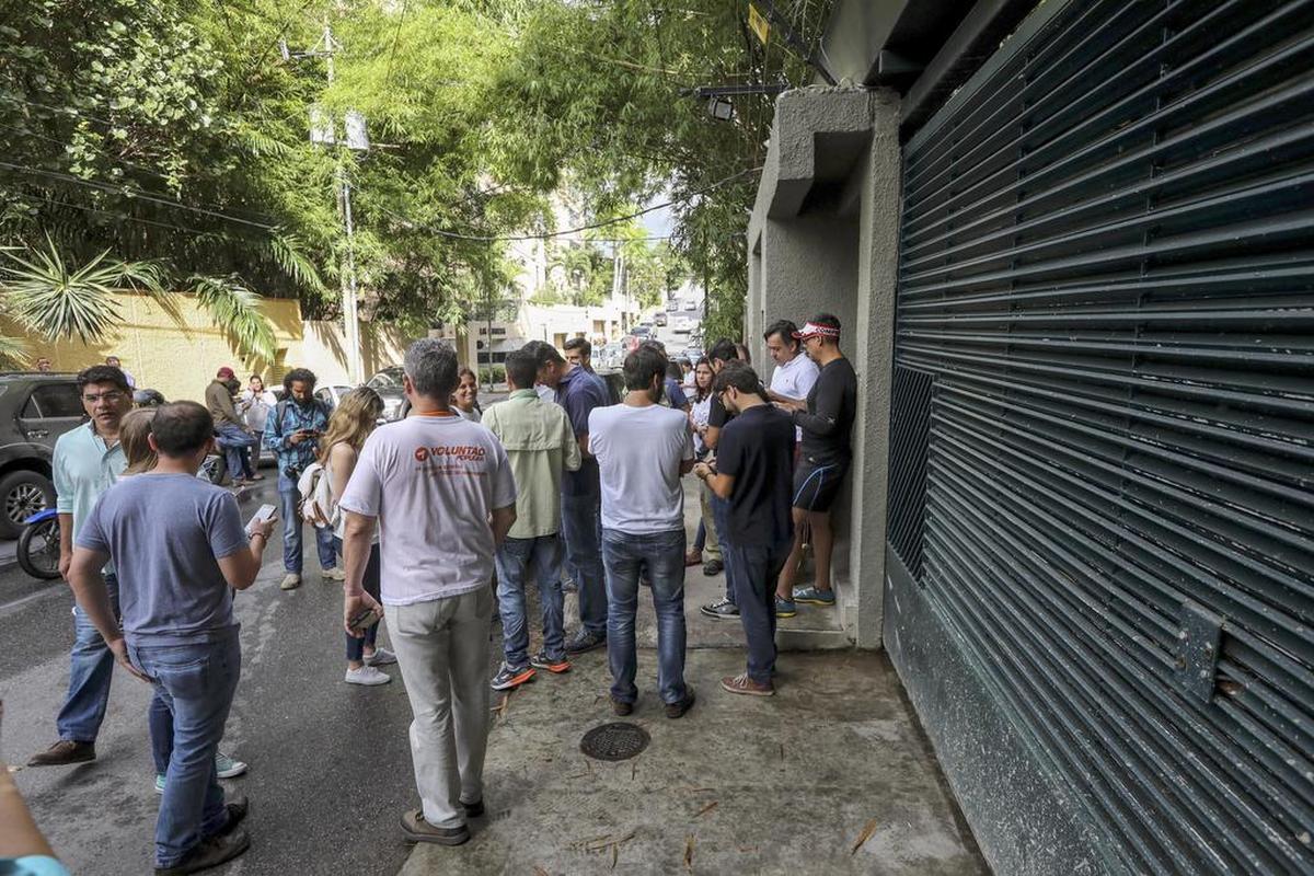 Familiares, miltantes del partido Voluntad Popular, junto a miembros del Servicio Bolivariano de Inteligencia Nacional (Sebin), permanecen en la entrada de la casa en Caracas del opositor venezolano Leopoldo López que ha abandonado la cárcel y ha pasado a estar en una situación de "arresto domiciliario".