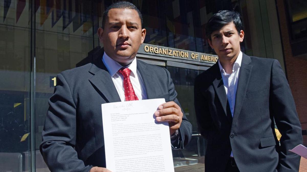 El coordinador mundial de los Estudiantes de Venezuela en el Exterior (EVE) Carlos Moreno (izq.) junto al coordinador de Boston, Diego Rojo, muestra el documento que entregaron al Departamento para la Cooperación y Observación Electoral de la OEA, en Washington, DC, el 16 de octubre de 2015. Los miembros de EVE denunciaron las dificultades a la hora de pagar matrículas universitarias, transporte o comida por retrasos del Gobierno de Nicolás Maduro para la entrega de divisas.