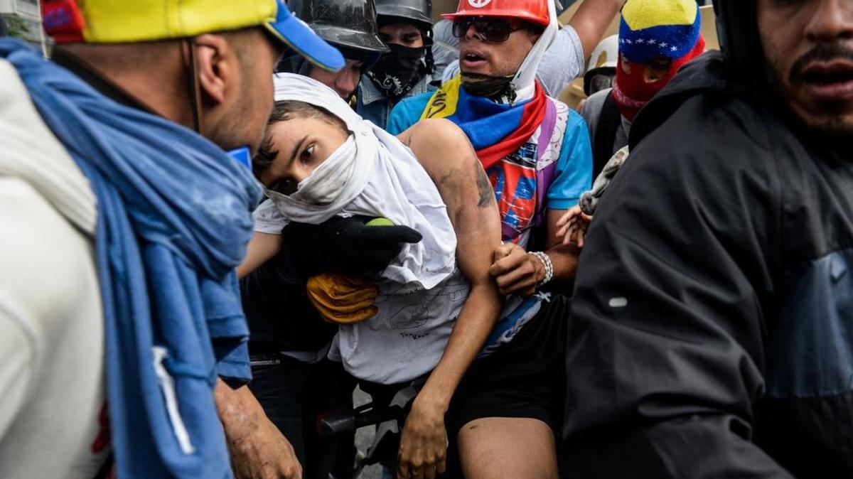 Un manifestante arrollado es llevado en brazos por otros integrantes de la protesta, el 3 de mayo en Caracas.