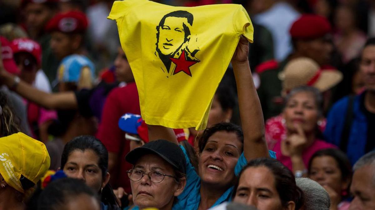 Una seguidora del chavismo sostiene una camiseta con la imagen del ex presidente venezolano Hugo Chávez en una manifestación en apoyo al presidente de Venezuela, Nicolás Maduro, el viernes 28 de octubre de 2016, en Caracas.