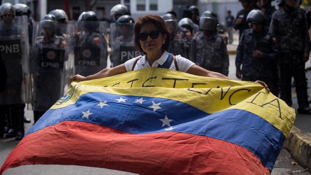 Una mujer ondea una bandera venezolana durante una marcha estudiantil en Caracas (Venezuela).