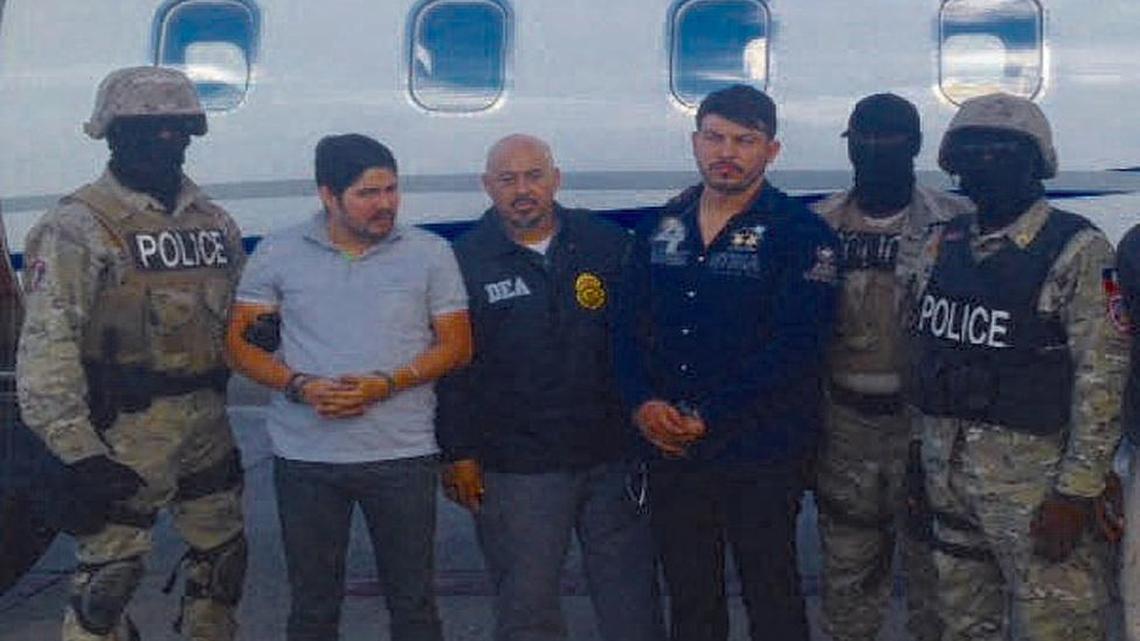 Efraín A. Campo, segundo de la izquierda y FRanki F. Flores , cuarto desde la izquierda, esposados después del arresto en Haití