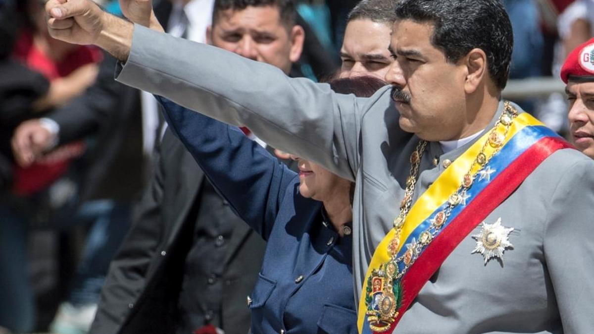 El gobernante venezolano Nicolás Maduro (der.) saluda a partidarios en un desfile militar en Caracas el 1ro de febrero.