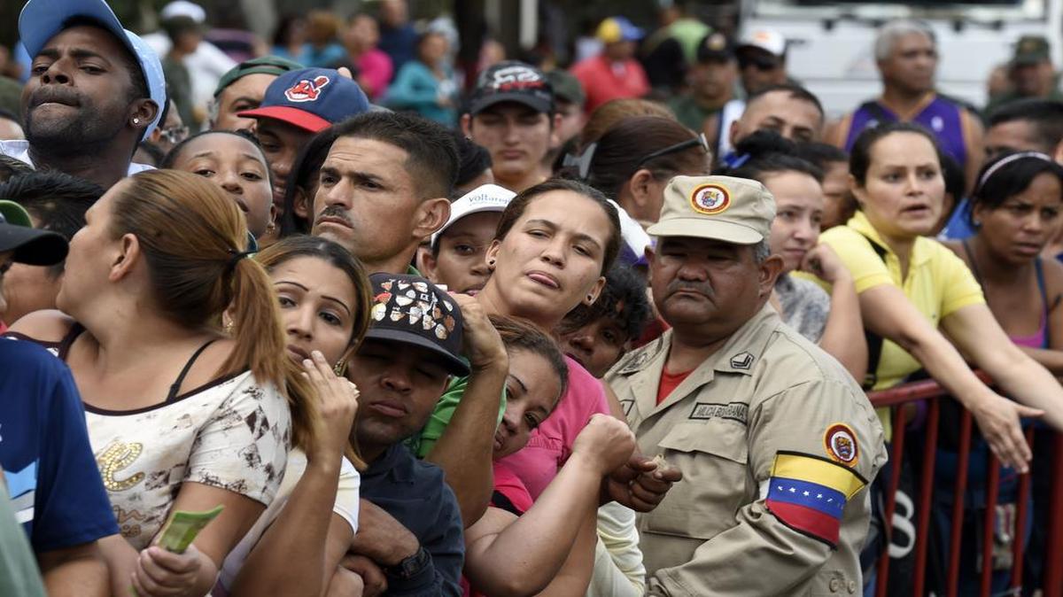 
Una larga fila de personas espera para poder comprar pollo en un mercado de Caracas en enero del 2015.
