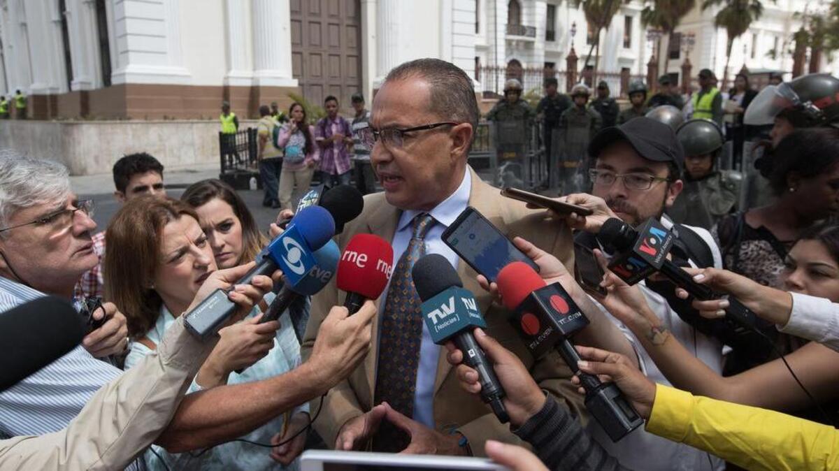 El diputado venezolano Richard Blanco habla con la prensa mientras miembros de la Guardia Nacional Bolivariana prestan guardia e impiden el paso de periodistas al edificio de la Asamblea Nacional el martes en Caracas (Venezuela).