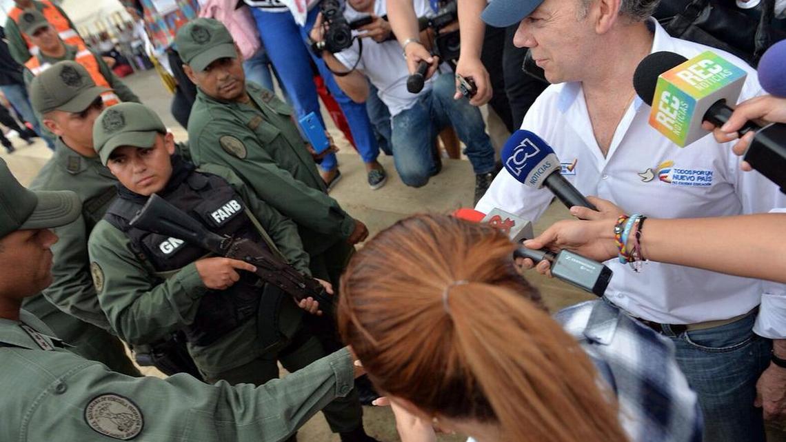 
El presidente de Colombia, Juan Manuel Santos (der.), saluda el martes a miembros de la Guardia Nacional de Venezuela, durante su visita al paso fronterizo de Paraguachón. 

