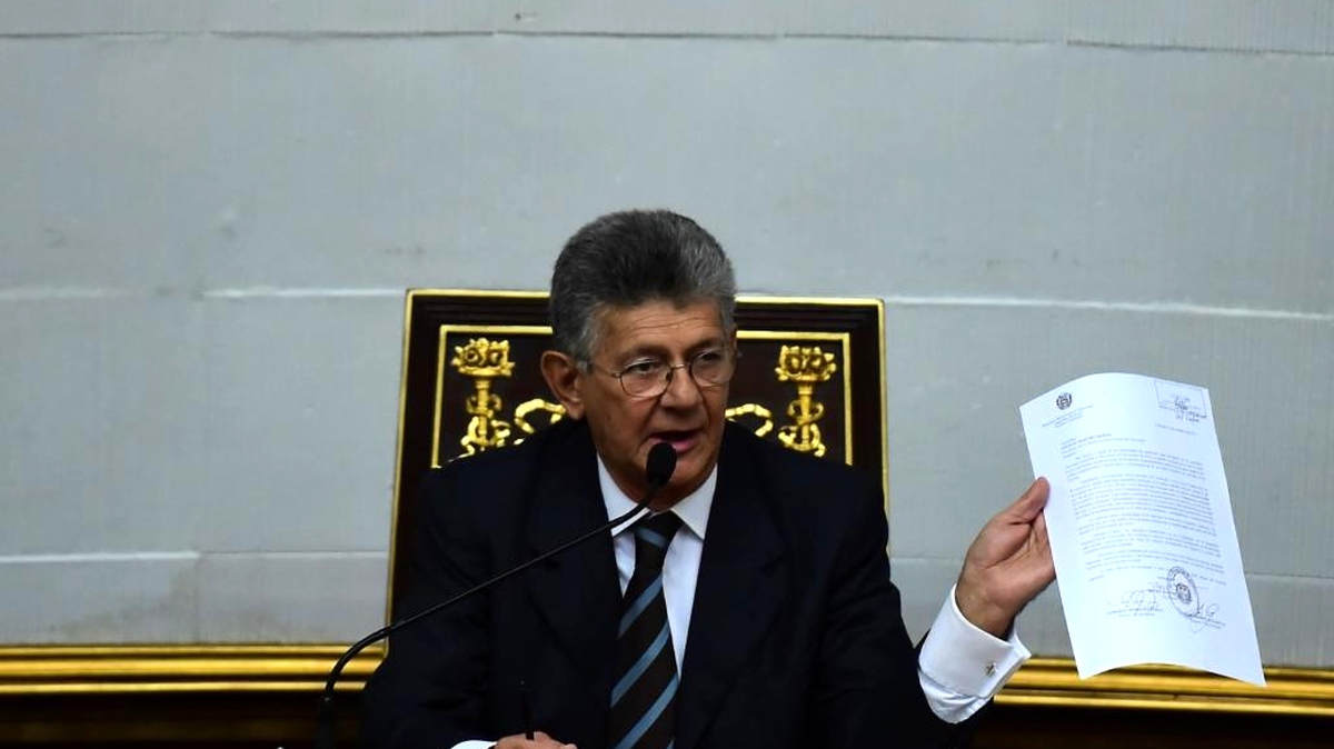 El presidente de la Asamblea Nacional de Venezuela, Henry Ramos Allup, muestra el documento de citación al presidente Nicolás Maduro.