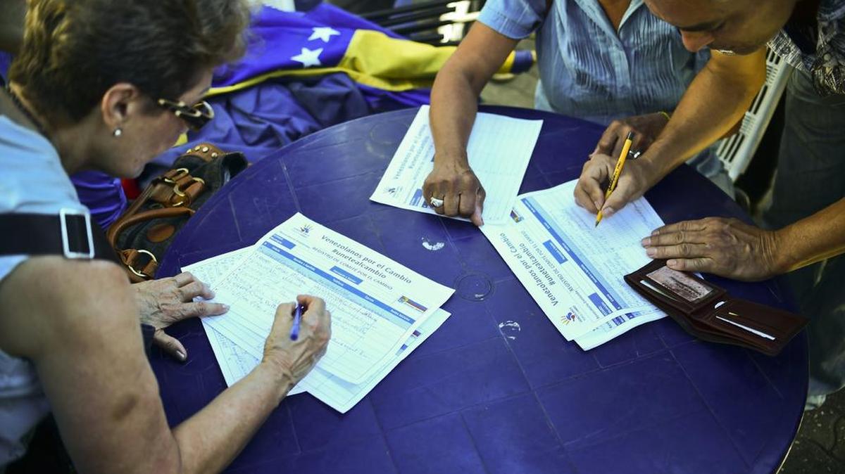 Esta foto de archivo tomada en junio del 2016 muestra a personas firmando por el revocatorio.