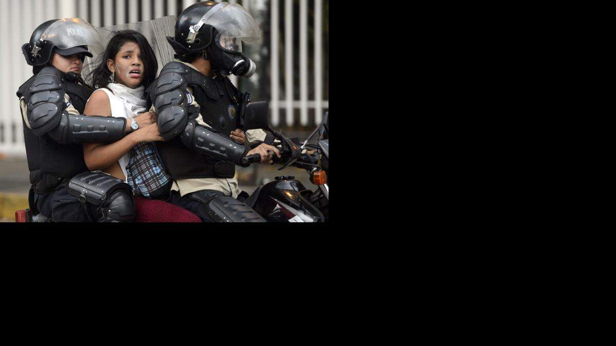 
Una manifestante antigubernamental es conducida bajo arresto por la policía en marzo pasado. La protestas de marzo y abril fueron reprimidas con violencia por la policía y paramilitares chavistas.
