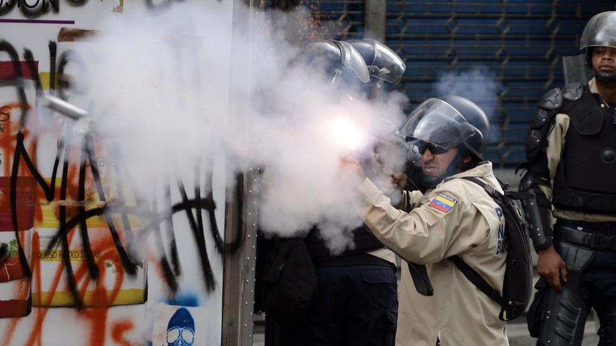 Un oficial de la policía venezolana dispara una ganada de gas lacrimógeno contra los manifestantes que protestaban contra el gobierno del presidente Nicolás Maduro en Caracas el 17 de abril de 2014.