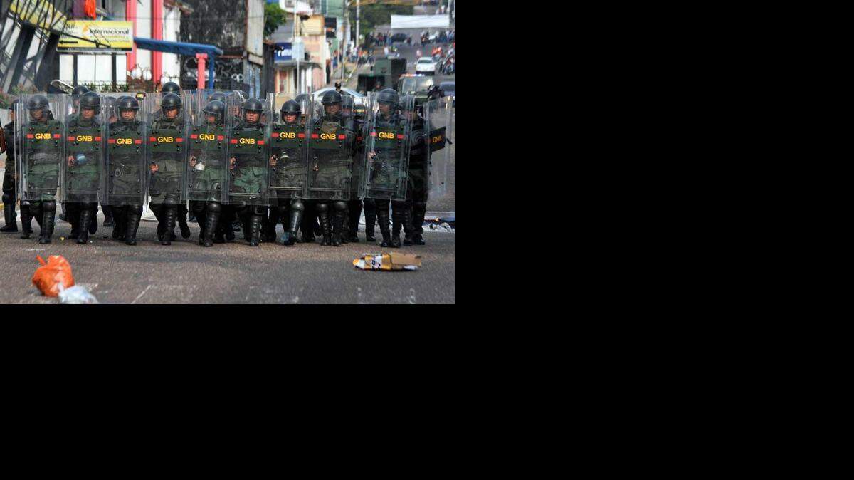 Soldados de la Guardia Nacional Bolivariana avanzan contra  manifestantes durante una protesta contra el gobierno en San Cristóbal, Venezuela, el martes, 24 de febrero de 2015.