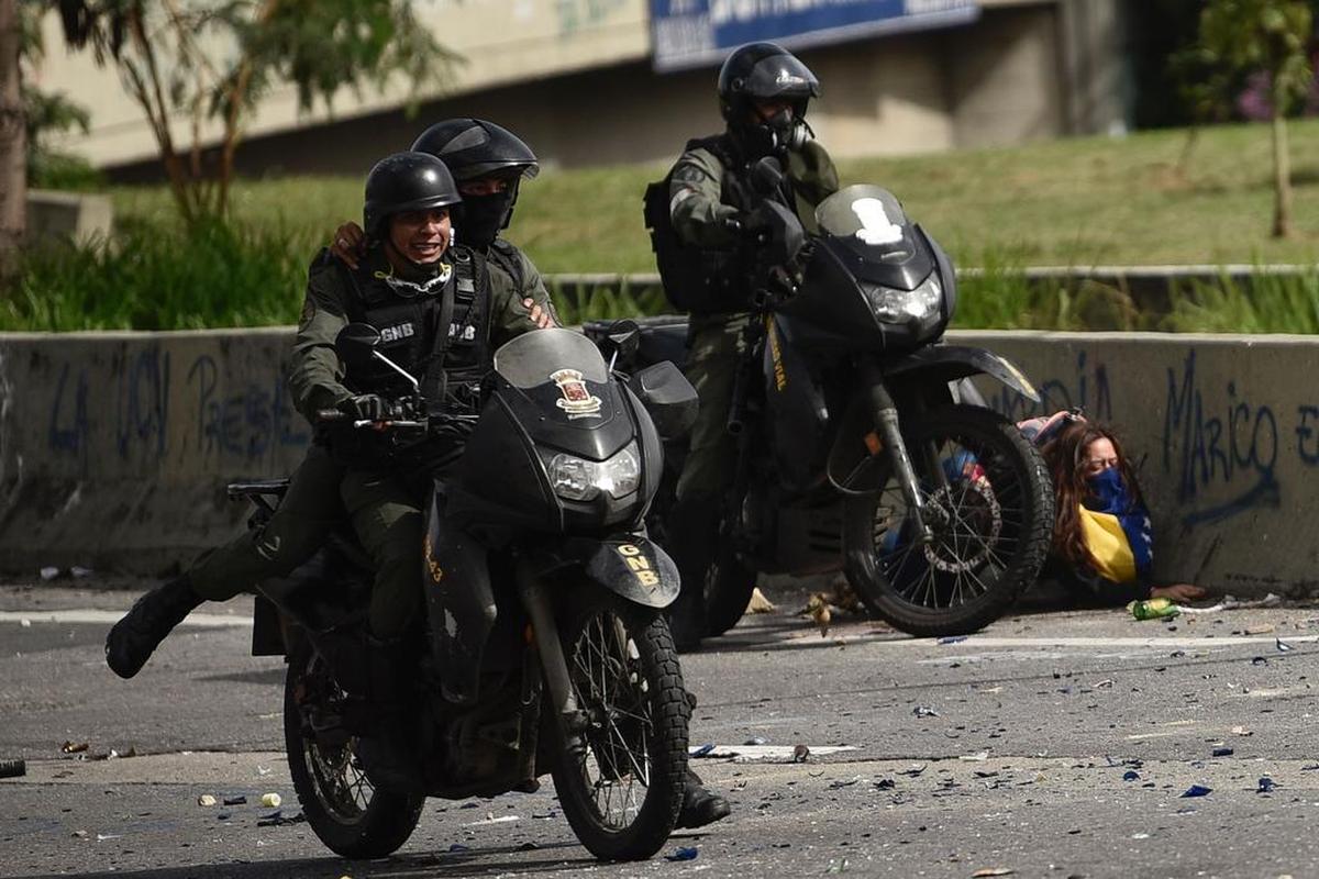Un miembro de la Guardia Nacional Bolivarian arresta a una mujer que protestaba contra el régimen de Nicolás Maduro el lunes en Caracas, Venezuela.
