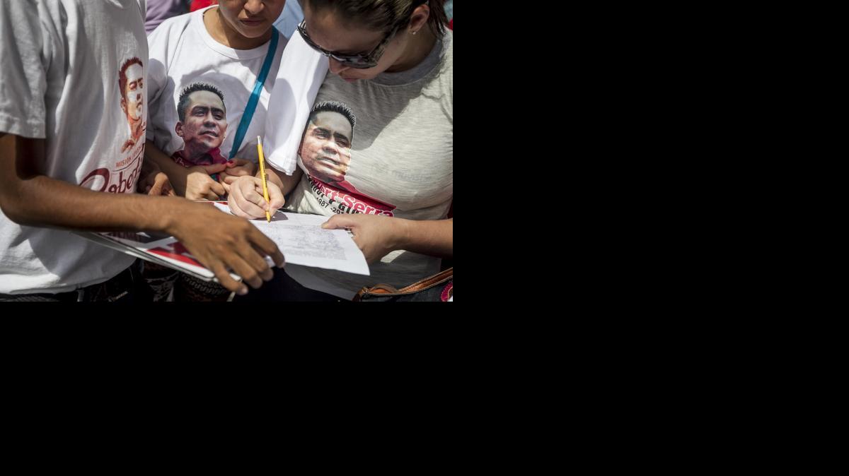 
Un manifestante firma durante una protesta por la muerte del diputado venezolano Robert Serra, el lunes 1 de diciembre del 2014, en Caracas (Venezuela). 
