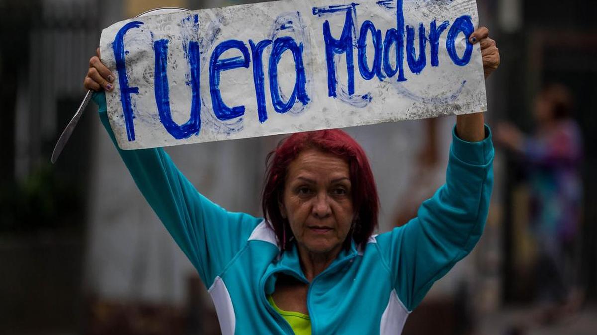 Una mujer sostiene un cartel en contra del presidente venezolano, Nicolás Maduro, durante una manifestación en contra del Gobierno venezolano hoy, lunes 24 de abril de 2017, en Caracas (Venezuela).