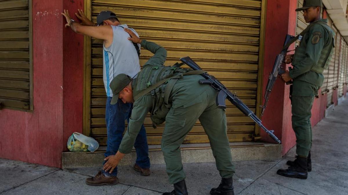  Integrantes del ejército venezolano inspeccionan a un transeúnte en las inmediaciones de la Aduana Principal fronteriza entre Colombia y Venezuela el domingo 30 de agosto de 2015, en la ciudad de San Antonio (Venezuela). 
