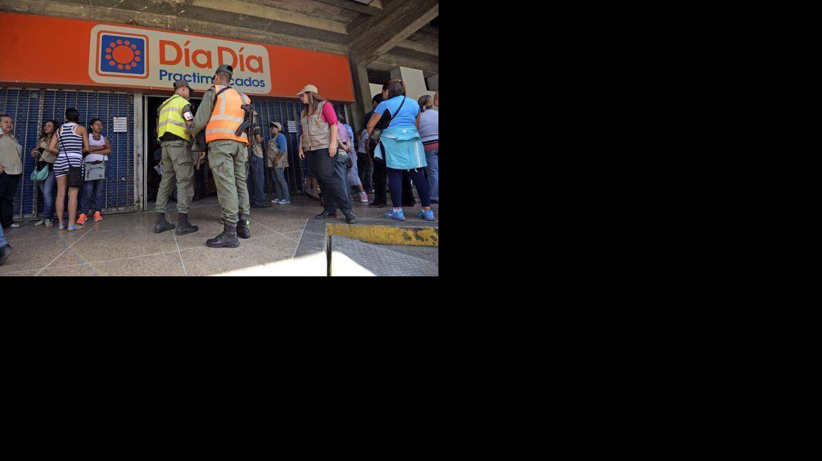 
Miembros de la Guardia Nacional de Venezuela patrullan frente a un supermercado de la cadena Día a Día en Caracas, de la cual el gobierno ha tomado control.
