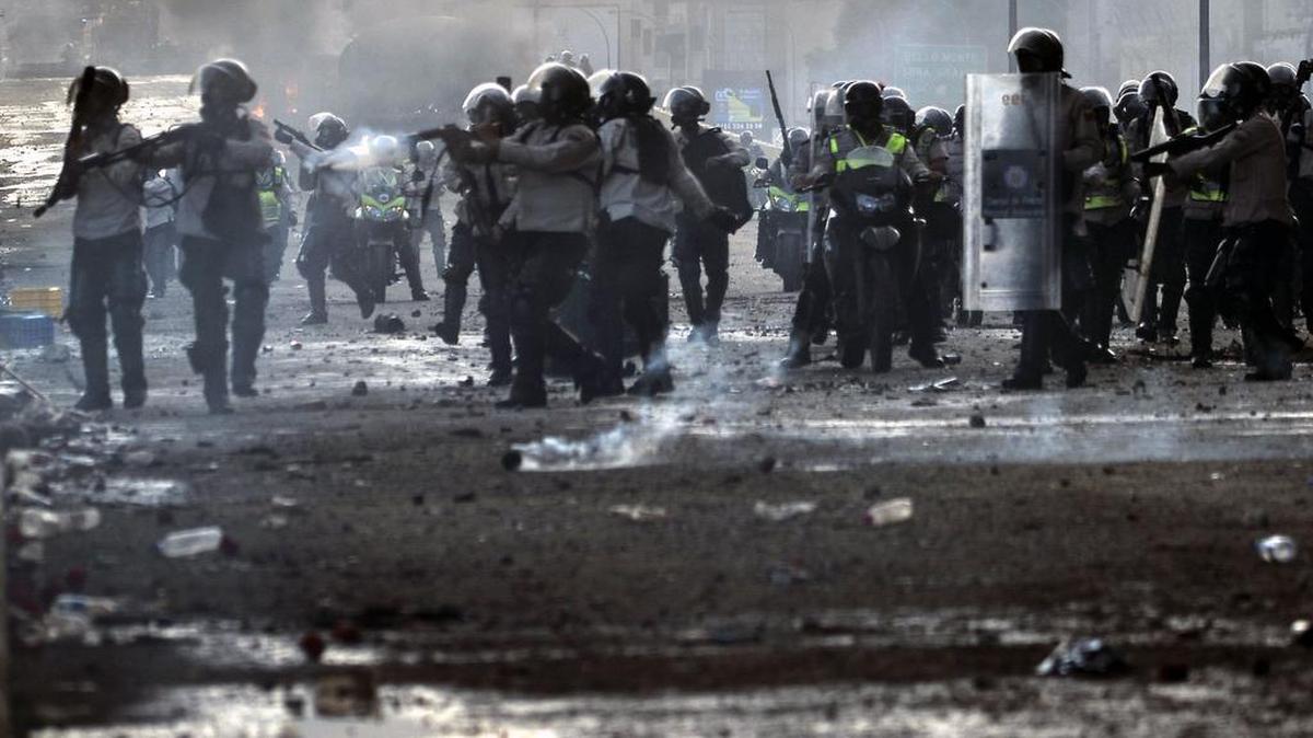 La policía antidisturbios choca con manifestantes que bloquean la carretera Francisco Fajardo durante una protesta contra el presidente venezolano Nicolás Maduro el 27 de mayo de 2017.