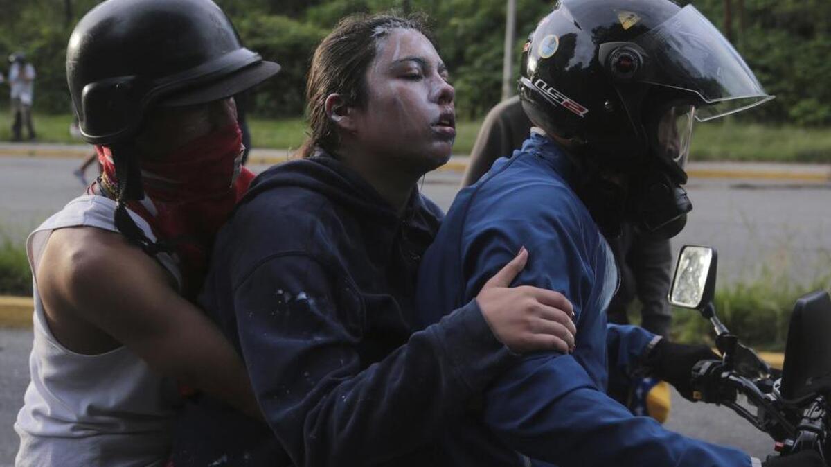 Un manifestante afectado por gases lacrimógenos es evacuado durante los enfrentamientos con la Guardia Nacional Bolivariana, en el municipio de El Hatillo, en las afueras de Caracas, Venezuela, el martes 2 de mayo de 2017.