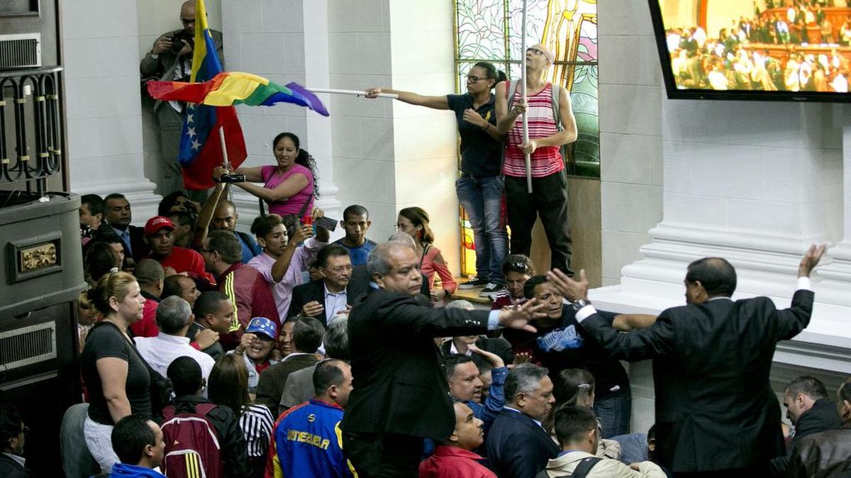 Un grupo de partidarios del gobierno ingresa por la fuerza en las instalaciones de la Asamblea Nacional en Caracas el 23 de octubre del 2016, para interrumpir una sesión en la que el parlamento consideraría presentar cargos contra el gobernante Nicolás Maduro.