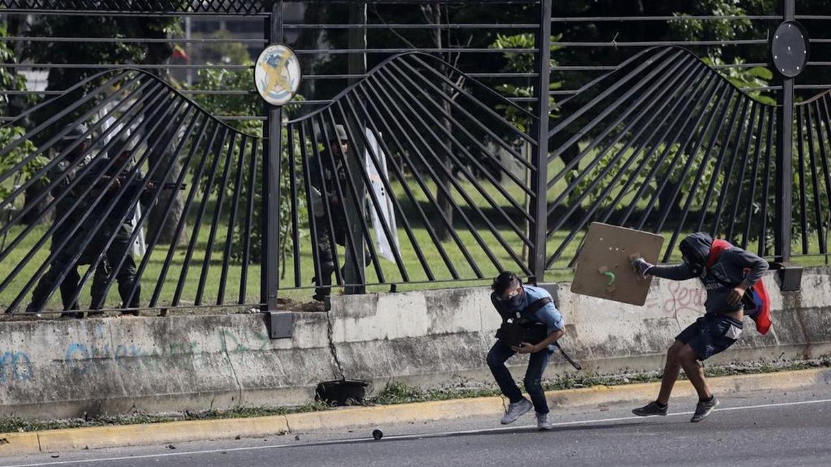 El joven David José Vallenilla (2d), de 22 años, recibe un disparo de un miembro de la Guardia Nacional Bolivariana (GNB) el jueves 22 de junio de 2017, en las inmediaciones de la bases aérea militar La Carlota, en Caracas.