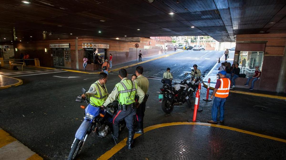 Policías prestan guardia en la entrada a un centro comercial hoy, miércoles 10 de febrero de 2016, en Caracas (Venezuela).
