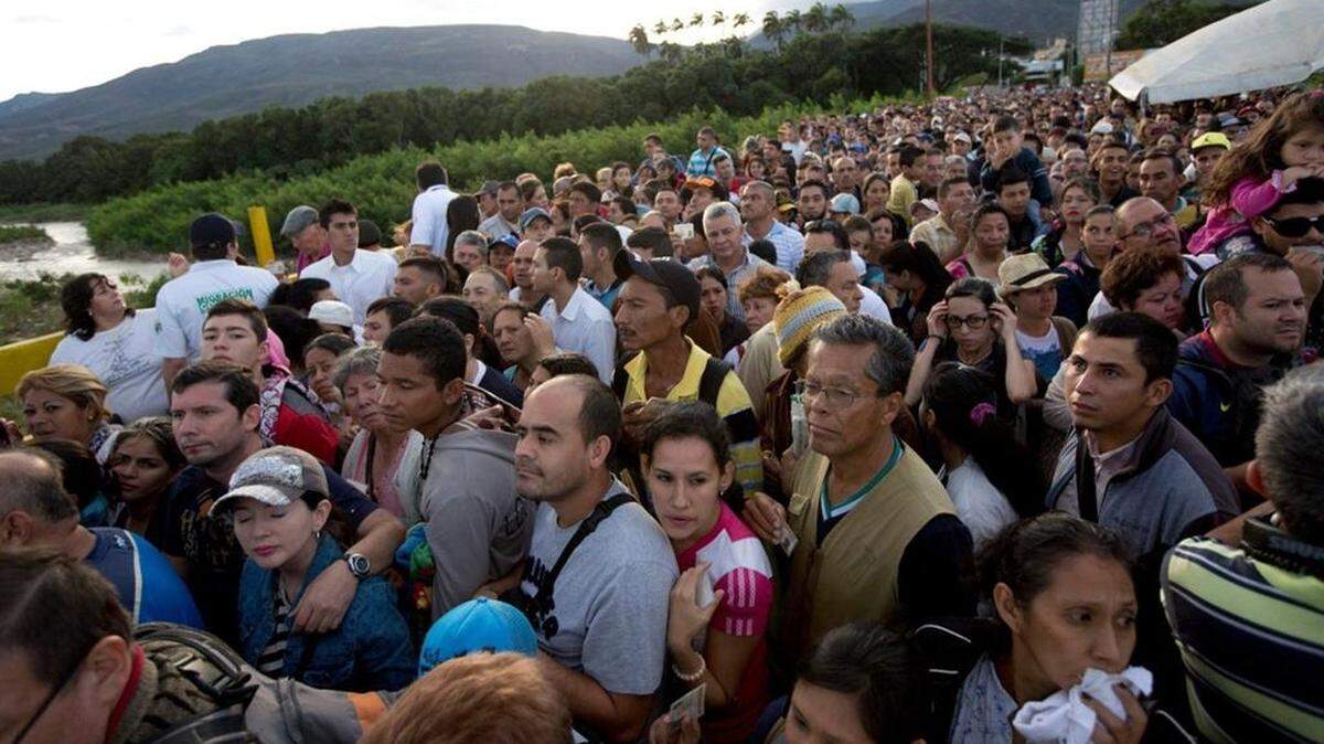 Venezuelans cross the Simon Bolivar bridge linking San Antonio del Tachira, Venezuela, with Cucuta, Colombia, to buy supplies, Sunday, July 17, 2016. Tens of thousands of Venezuelans crossed the border into Colombia on Sunday to hunt for food and medicine that are in short supply at home. It’s the second weekend in a row that Venezuelaâ??s government has opened the long-closed border connecting Venezuela to Colombia, and by 6 a.m., a line of would-be shoppers snaked through the entire town of San Antonio del Tachira. (AP Photo/Ariana Cubillos)