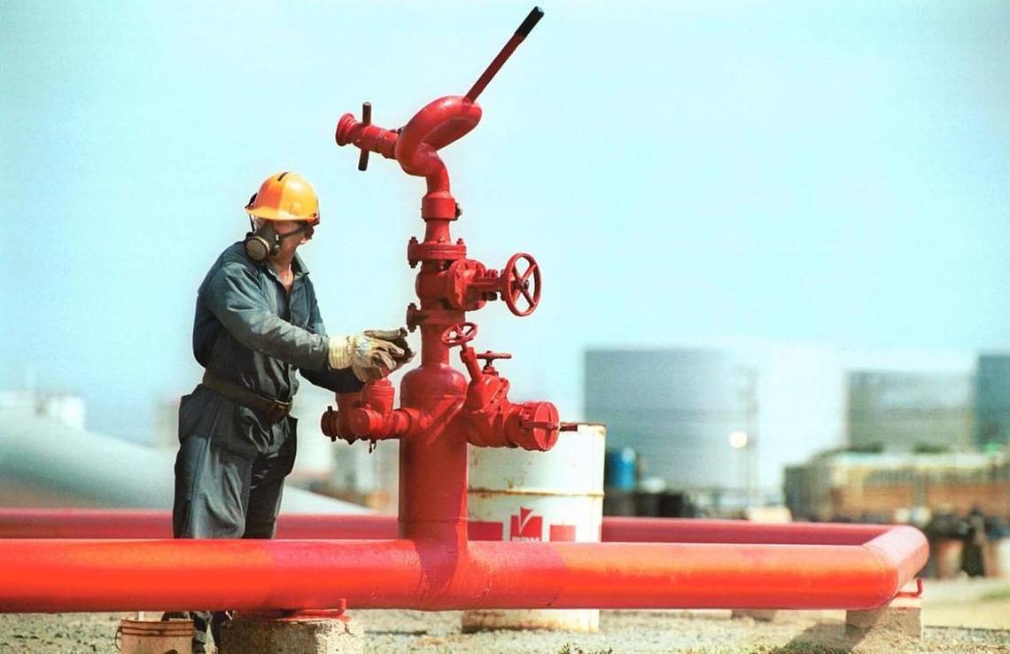 A worker opens a valve at the Amuay oil refinery near Punto Fijo, Venezuela, on April 25, 2002. The largest oil refinery in Latin America, Amuay is owned by Petróleos de Venezuela, S.A. (PDVSA), the state oil company. Photographer: Diego Giudice/Bloomberg News