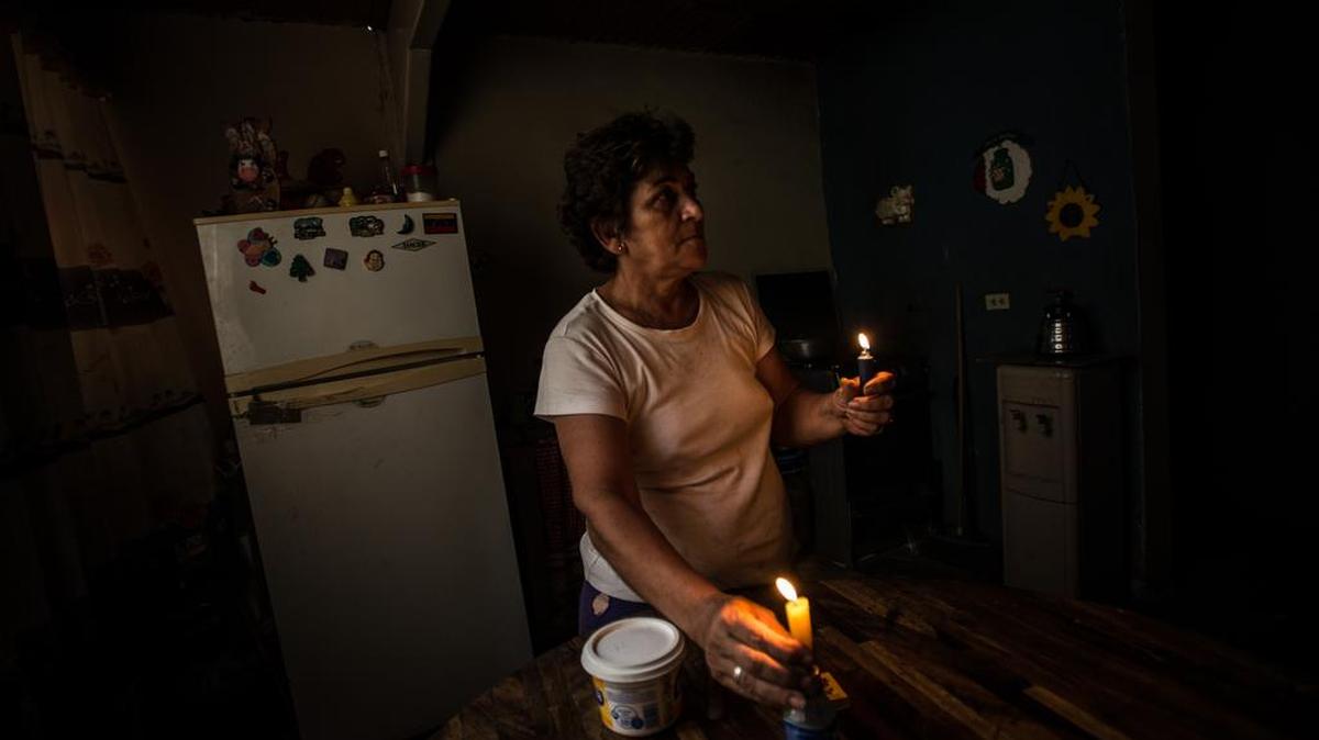 Nadia Rodríguez, de 54 años de edad, se alumbra el jueves con velas en medio de un apagón en Maracay, Venezuela.