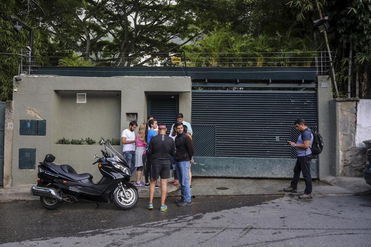 Familiares y miembros del Servicio Bolivariano de Inteligencia Nacional (Sebin), permanecen en la entrada de la casa en Caracas del opositor venezolano Leopoldo López que ha abandonado la cárcel y ha pasado a estar en una situación de "arresto domiciliario".