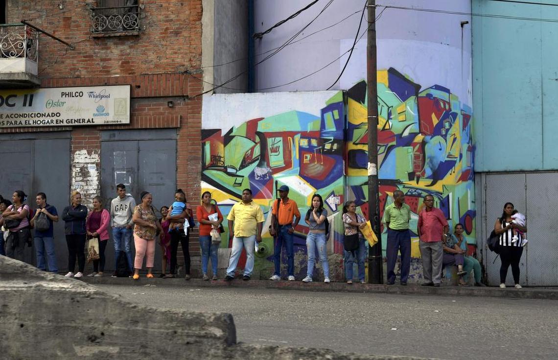 Los ciudadanos venezolanos esperan un transporte público en una parada de autobús en Caracas, Venezuela, el 3 de enero de 2018.