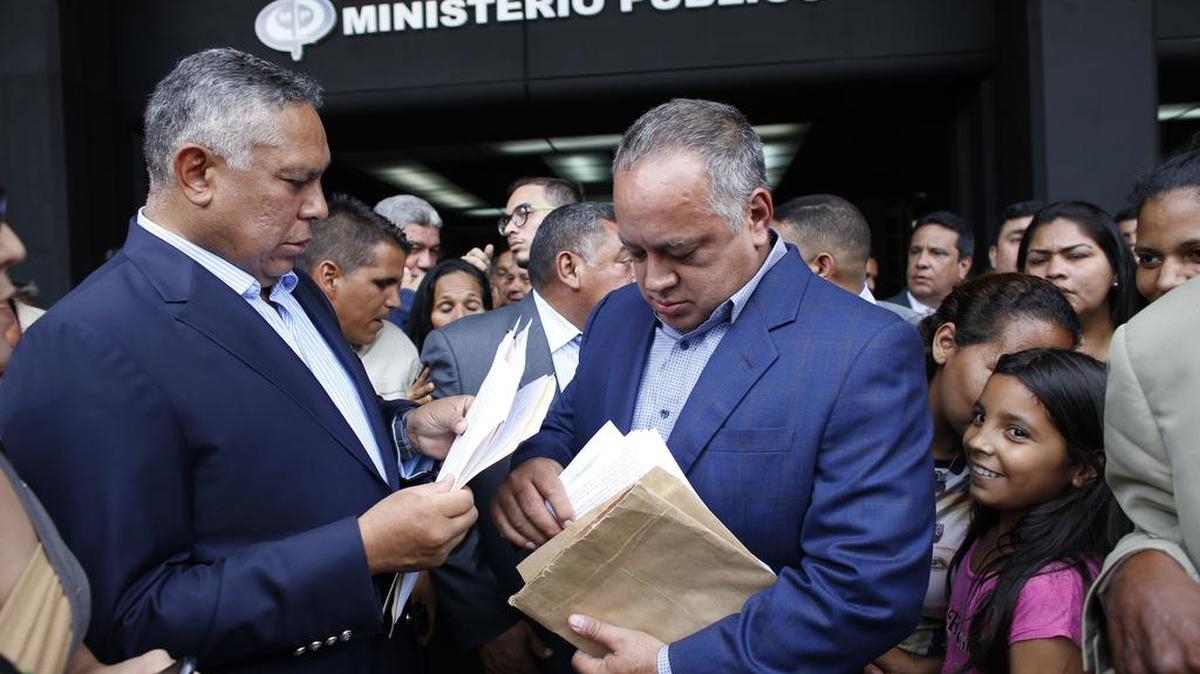 El delegado venezolano de la Asamblea Constituyente y líder del partido socialista gobernante de Venezuela, Diosdado Cabello, y su colega Pedro Carreno hojean papeles al salir de la Fiscalía General de Caracas, Venezuela, miércoles 16 de agosto de 2017.