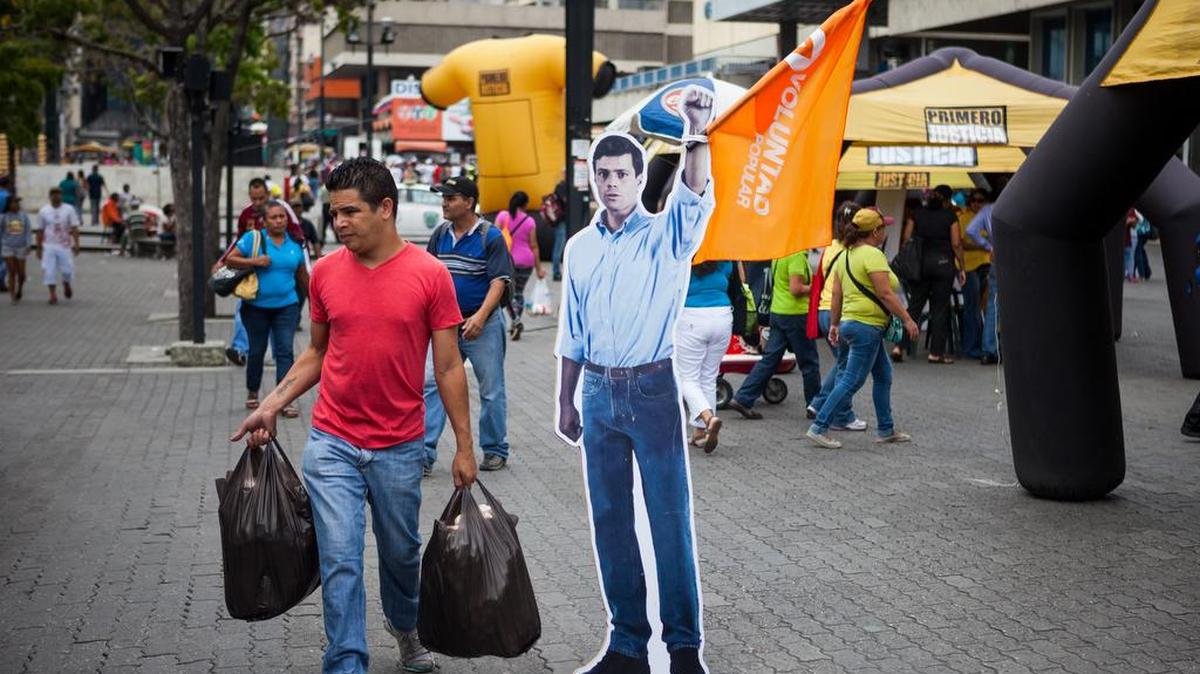 Un ciudadano camina frente a una imagen del dirigente opositor encarcelado Leopoldo López, del partido Voluntad Popular, el sábado 28 de noviembre de 2015, en Caracas, Venezuela.