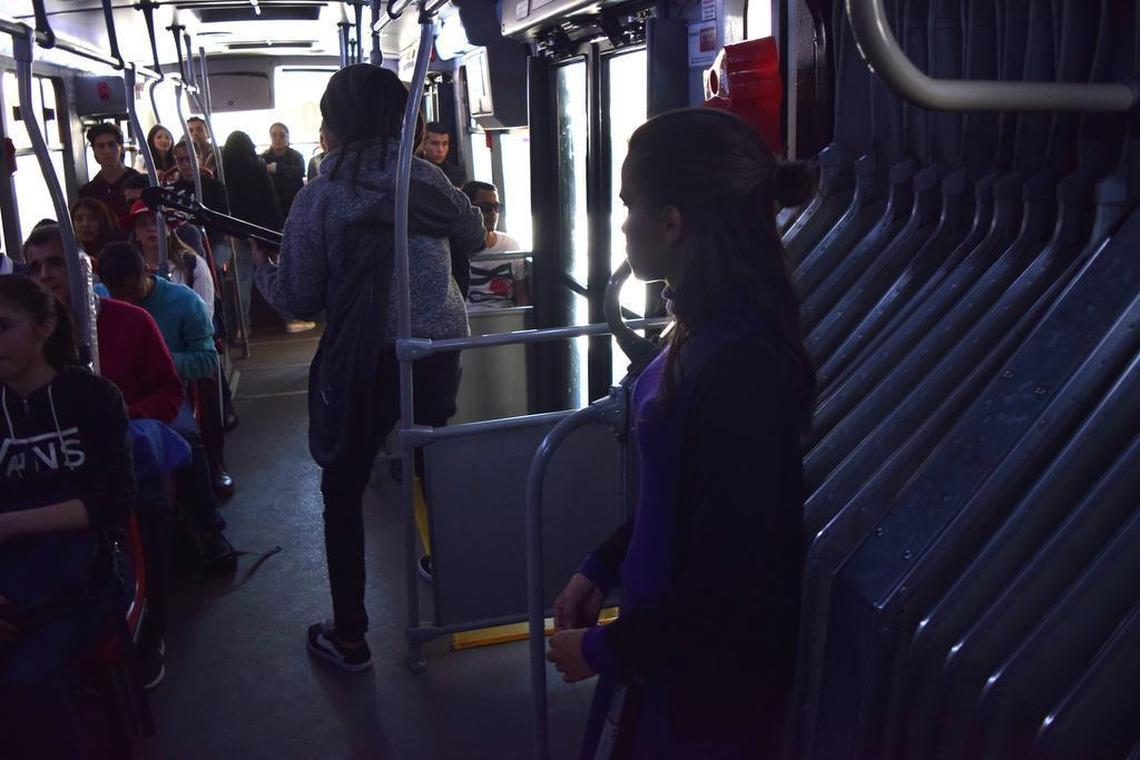 Mery Muñoz (en primer plano) observa a un grupo de músicos venezolanos tocar en un autobús en Bogotá, Colombia. Muñoz y su mamá han solicitado asilo político en Colombia, pero no les permiten trabajar mientras las autoridades procesan la solicitud.