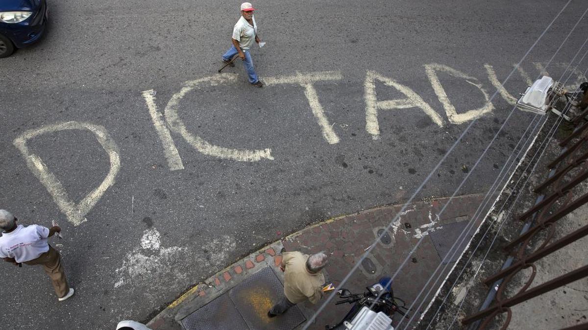 Un letrero en el pavimento es muestra del largo enfrentamiento de los venezolanos con el gobierno de Nicolás Maduro.