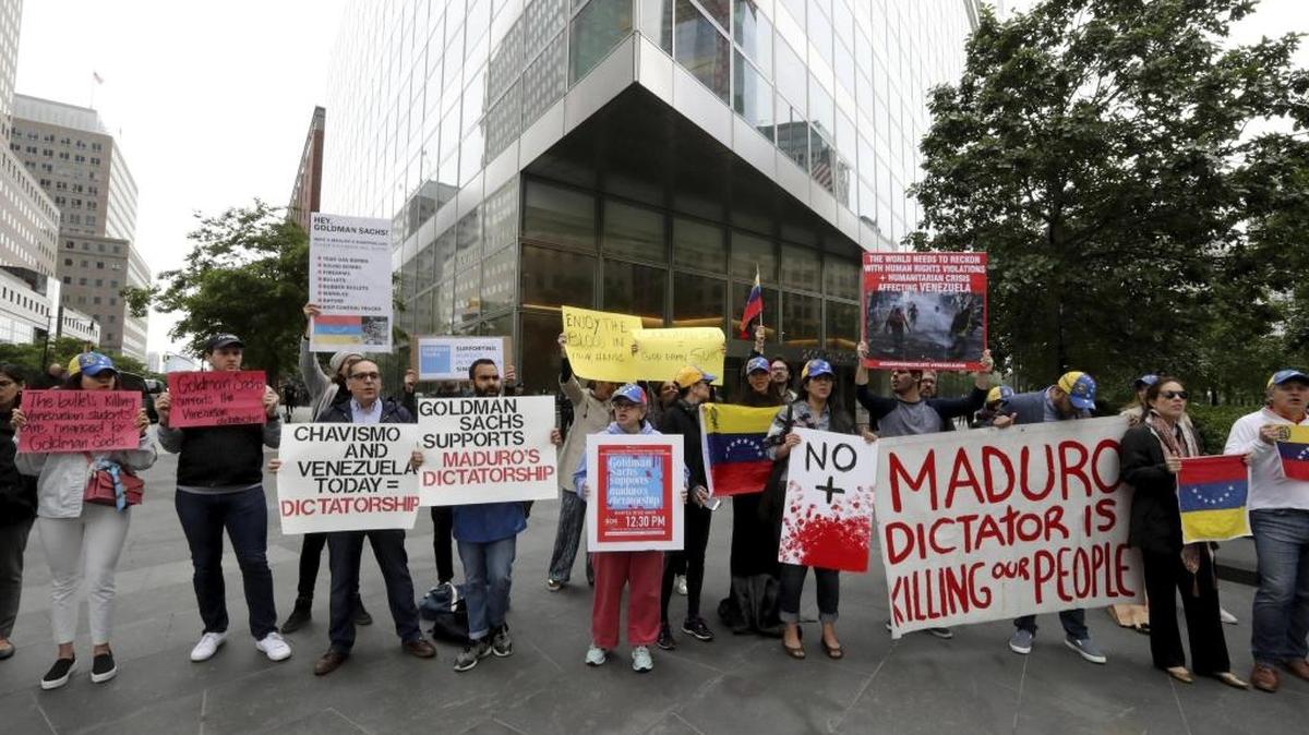 Varias personas participan en una manifestación contra la firma estadounidense de inversiones Goldman Sachs en rechazo a la supuesta compra de 2.800 millones de dólares en bonos al Banco Central de Venezuela en frente de dicha firma en Nueva York, Estados Unidos.