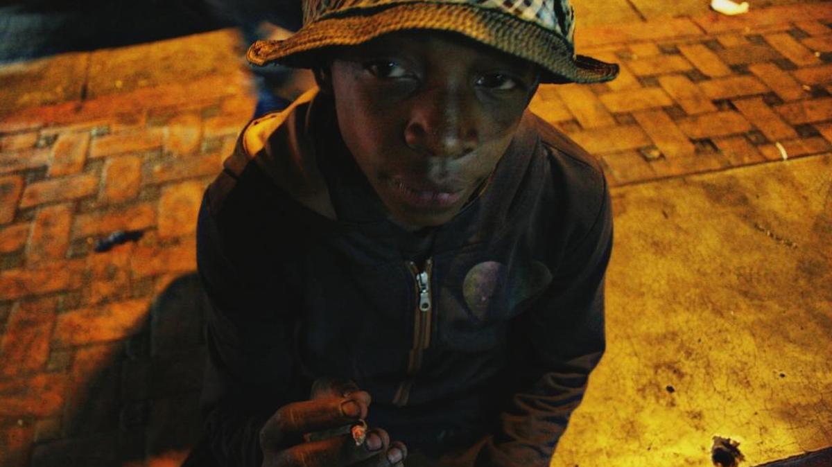Yordi, de 14 años y miembro de la pandilla Chacao, fuma en una calle de Caracas, Venezuela.