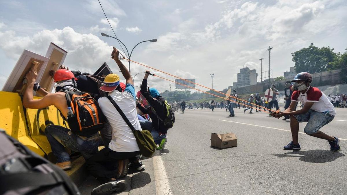 Manifestantes de la oposición usan una honda en enfrentamientos con la policía antidisturbios durante una protesta contra el presidente venezolano Nicolás Maduro en Caracas, el 31 de mayo de 2017.