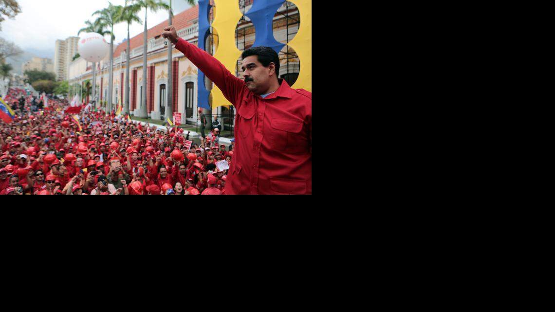 
Con el puño en alto, el presidente Nicolás Maduro saluda a sus partidarios reunidos en una calle de Caracas en febrero de este año.
